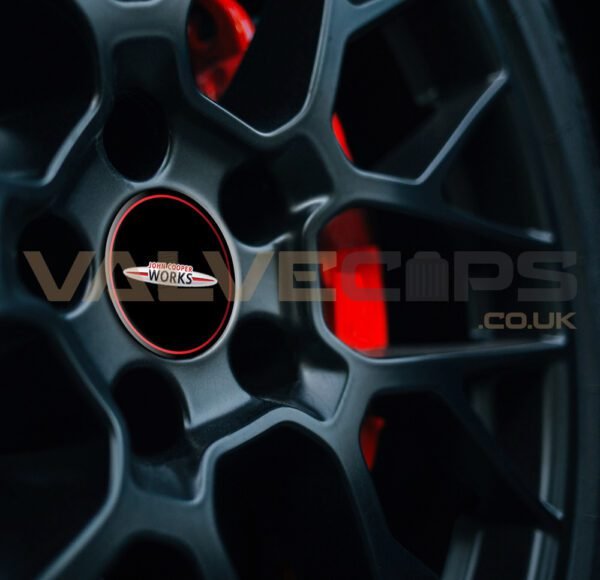 This image shows a JCW (John Cooper Works) wheel centre cap badge fitted to a black alloy wheel